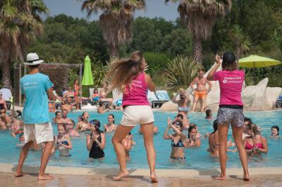 Toboggans aquatiques sinueux entourés de végétation tropicale avec des éléments décoratifs colorés en premier plan.