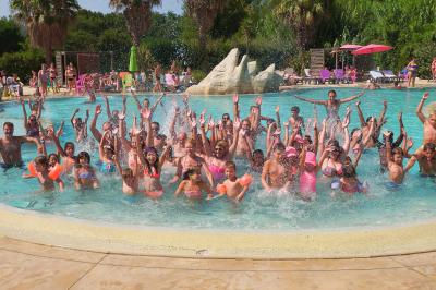 Toboggans aquatiques sinueux entourés de végétation tropicale avec des éléments décoratifs colorés en premier plan.