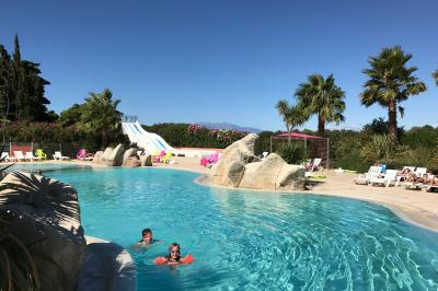 Toboggans aquatiques sinueux entourés de végétation tropicale avec des éléments décoratifs colorés en premier plan.