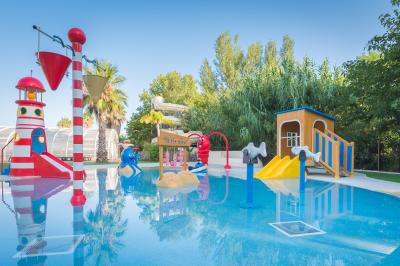 Toboggans aquatiques sinueux entourés de végétation tropicale avec des éléments décoratifs colorés en premier plan.