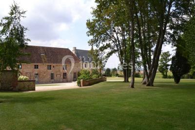 Chambre avec un lit double, un lit simple, deux lampes de chevet allumées et une fenêtre avec rideaux gris.