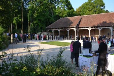 Chambre avec un lit double, un lit simple, deux lampes de chevet allumées et une fenêtre avec rideaux gris.