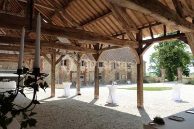 Chambre avec un lit double, un lit simple, deux lampes de chevet allumées et une fenêtre avec rideaux gris.