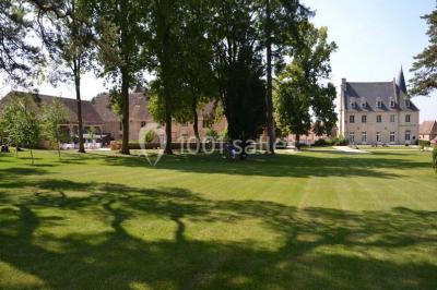 Chambre avec un lit double, un lit simple, deux lampes de chevet allumées et une fenêtre avec rideaux gris.