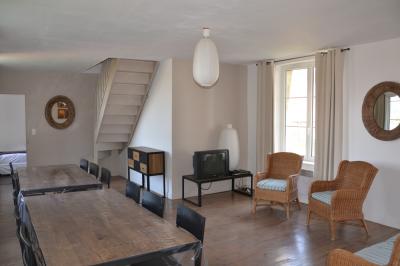 Chambre avec un lit double, un lit simple, deux lampes de chevet allumées et une fenêtre avec rideaux gris.