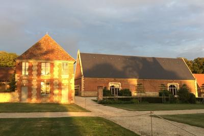 Chambre avec un lit double, un lit simple, deux lampes de chevet allumées et une fenêtre avec rideaux gris.