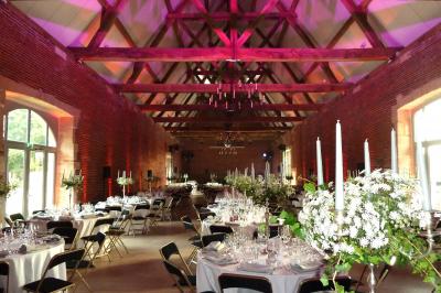 Chambre avec un lit double, un lit simple, deux lampes de chevet allumées et une fenêtre avec rideaux gris.