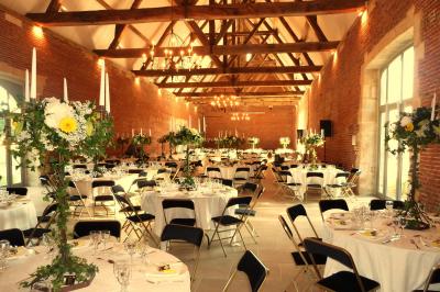 Chambre avec un lit double, un lit simple, deux lampes de chevet allumées et une fenêtre avec rideaux gris.