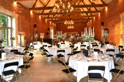 Chambre avec un lit double, un lit simple, deux lampes de chevet allumées et une fenêtre avec rideaux gris.