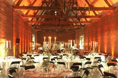 Chambre avec un lit double, un lit simple, deux lampes de chevet allumées et une fenêtre avec rideaux gris.