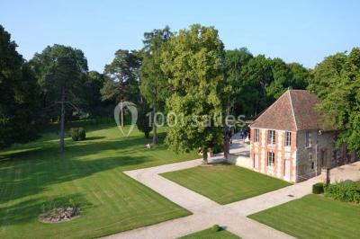 Chambre avec un lit double, un lit simple, deux lampes de chevet allumées et une fenêtre avec rideaux gris.