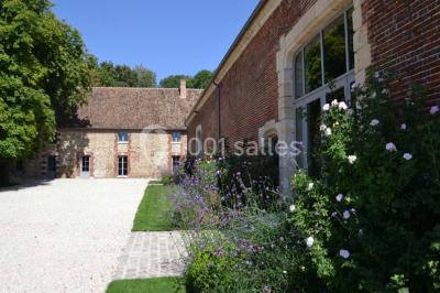 Chambre avec un lit double, un lit simple, deux lampes de chevet allumées et une fenêtre avec rideaux gris.