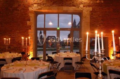 Chambre avec un lit double, un lit simple, deux lampes de chevet allumées et une fenêtre avec rideaux gris.