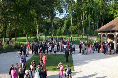 Chambre avec un lit double, un lit simple, deux lampes de chevet allumées et une fenêtre avec rideaux gris.