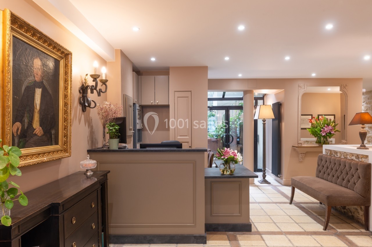 Réception d'un intérieur élégant avec mobilier classique, tableau ancien, éclairage chaleureux et plantes décoratives.