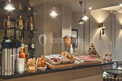 Chambre lumineuse avec un lit double, des murs clairs, des rideaux à rayures et des appliques murales allumées.