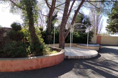 Vue aérienne d'une maison avec toit en tuiles, piscine rectangulaire et jardin arboré dans un cadre rural.
