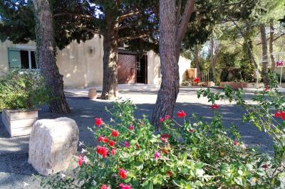 Vue aérienne d'une maison avec toit en tuiles, piscine rectangulaire et jardin arboré dans un cadre rural.