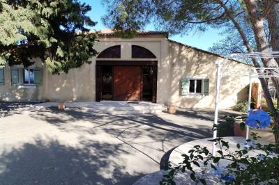 Vue aérienne d'une maison avec toit en tuiles, piscine rectangulaire et jardin arboré dans un cadre rural.