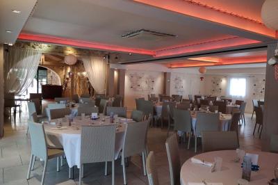 Vue aérienne d'une maison avec toit en tuiles, piscine rectangulaire et jardin arboré dans un cadre rural.