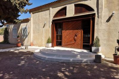 Vue aérienne d'une maison avec toit en tuiles, piscine rectangulaire et jardin arboré dans un cadre rural.