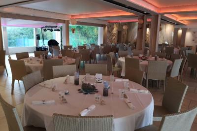 Vue aérienne d'une maison avec toit en tuiles, piscine rectangulaire et jardin arboré dans un cadre rural.