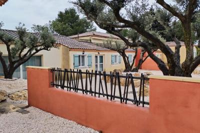 Vue aérienne d'une maison avec toit en tuiles, piscine rectangulaire et jardin arboré dans un cadre rural.