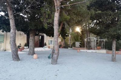 Vue aérienne d'une maison avec toit en tuiles, piscine rectangulaire et jardin arboré dans un cadre rural.