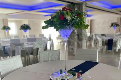 Vue aérienne d'une maison avec toit en tuiles, piscine rectangulaire et jardin arboré dans un cadre rural.