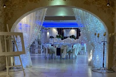Vue aérienne d'une maison avec toit en tuiles, piscine rectangulaire et jardin arboré dans un cadre rural.