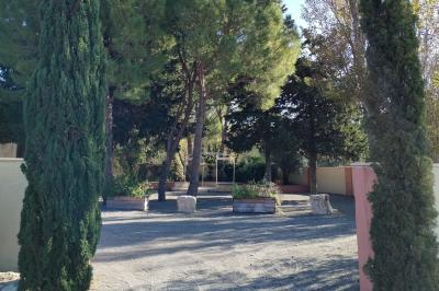 Vue aérienne d'une maison avec toit en tuiles, piscine rectangulaire et jardin arboré dans un cadre rural.