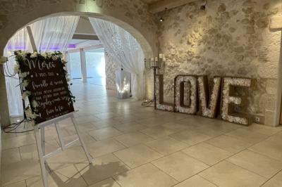 Vue aérienne d'une maison avec toit en tuiles, piscine rectangulaire et jardin arboré dans un cadre rural.