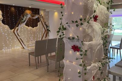 Vue aérienne d'une maison avec toit en tuiles, piscine rectangulaire et jardin arboré dans un cadre rural.