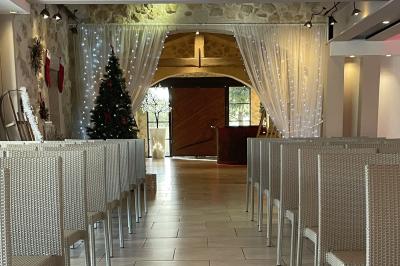 Vue aérienne d'une maison avec toit en tuiles, piscine rectangulaire et jardin arboré dans un cadre rural.