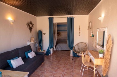 Vue aérienne d'une maison avec toit en tuiles, piscine rectangulaire et jardin arboré dans un cadre rural.