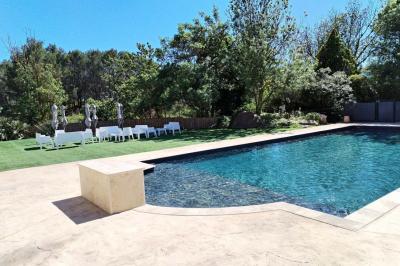 Chambre avec un lit double, mur décoré d'une photo de plage et éclairage doux avec appliques et lampes de chevet.