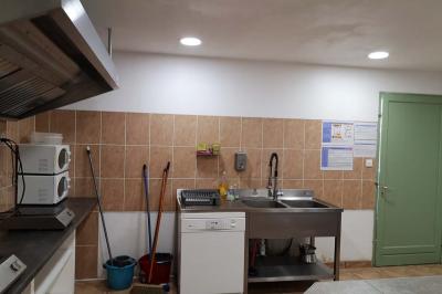 Chambre avec un lit double, mur décoré d'une photo de plage et éclairage doux avec appliques et lampes de chevet.