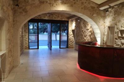 Chambre avec un lit double, mur décoré d'une photo de plage et éclairage doux avec appliques et lampes de chevet.