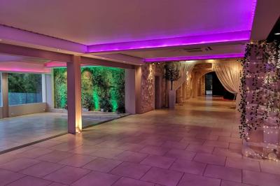 Chambre avec un lit double, mur décoré d'une photo de plage et éclairage doux avec appliques et lampes de chevet.