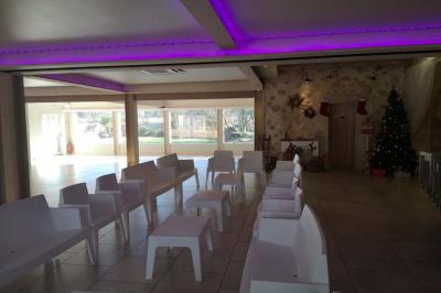 Chambre avec un lit double, mur décoré d'une photo de plage et éclairage doux avec appliques et lampes de chevet.