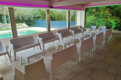 Chambre avec un lit double, mur décoré d'une photo de plage et éclairage doux avec appliques et lampes de chevet.