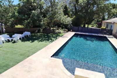 Chambre avec un lit double, mur décoré d'une photo de plage et éclairage doux avec appliques et lampes de chevet.