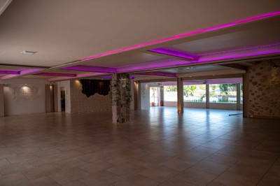 Chambre avec un lit double, mur décoré d'une photo de plage et éclairage doux avec appliques et lampes de chevet.