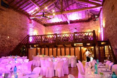 Vue d'un château en pierre entouré d'arbres et d'une pelouse bien entretenue sous un ciel dégagé.