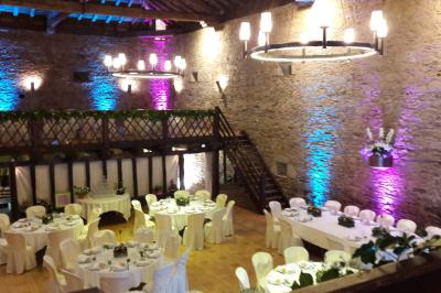 Vue d'un château en pierre entouré d'arbres et d'une pelouse bien entretenue sous un ciel dégagé.