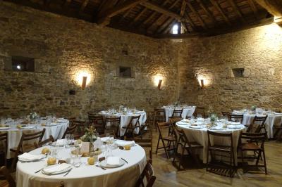 Vue d'un château en pierre entouré d'arbres et d'une pelouse bien entretenue sous un ciel dégagé.