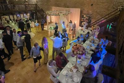 Vue d'un château en pierre entouré d'arbres et d'une pelouse bien entretenue sous un ciel dégagé.
