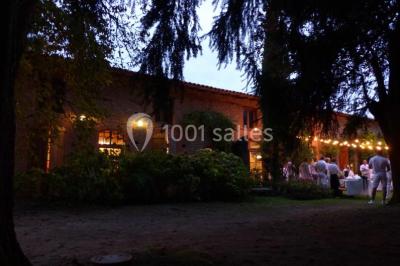 Vue sur les toits d'une ville avec un clocher en pierre et une tour en bois surmontée d'une cloche.