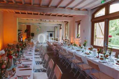 Vue sur les toits d'une ville avec un clocher en pierre et une tour en bois surmontée d'une cloche.