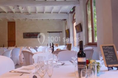 Vue sur les toits d'une ville avec un clocher en pierre et une tour en bois surmontée d'une cloche.